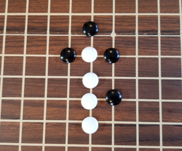 Black stones are used to block a line of white stones from further expanding.